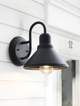 The light beside a white door frame and a house number on white lap siding