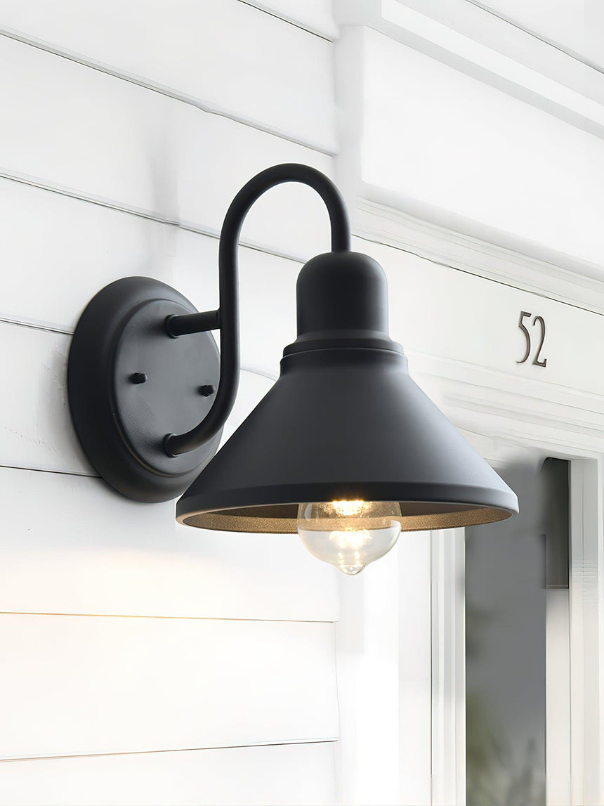The light beside a white door frame and a house number on white lap siding