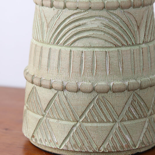 Close view of the carved bands and crosshatching on the pale patina base