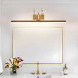 Gold antler bar lit above a framed mirror on a vanity with flowers and a tap