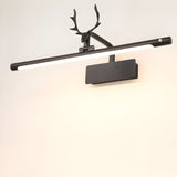 The black version lit on a pale wall, the antlers dark against the bright tube