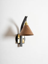 Curved arm sconce seen at an angle showing how far it reaches out