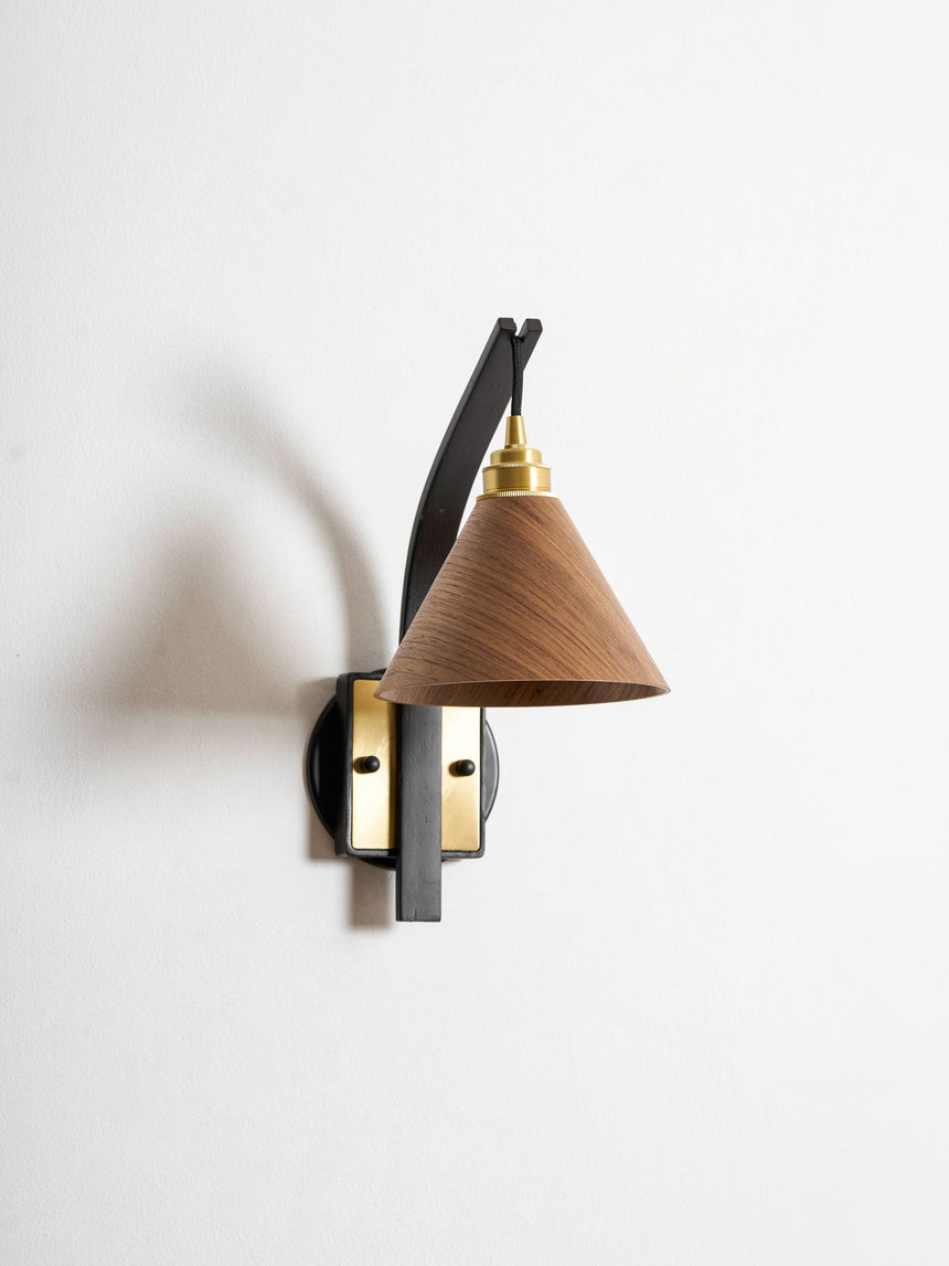 Curved arm sconce seen at an angle showing how far it reaches out