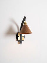 Side view of the curved arm and the cone shade on a plain wall