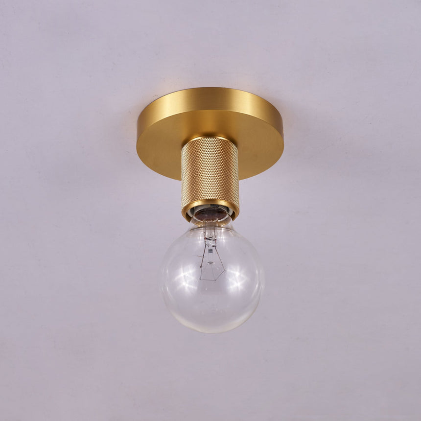 Brushed brass disc ceiling light with an unlit clear globe bulb