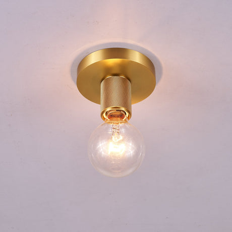 Brushed brass disc ceiling light lit against a pale gray ceiling