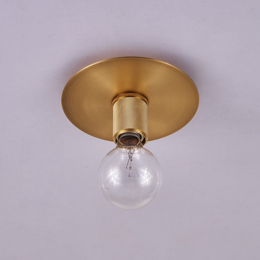 Brushed brass disc ceiling light with the bulb seen from the side