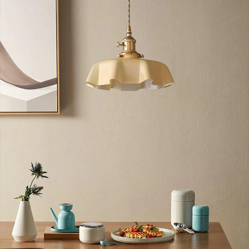 Beige scalloped shade above a dining corner with cups and a soft artwork