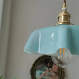 Close view of the blue scalloped rim with a clear bulb hanging below it
