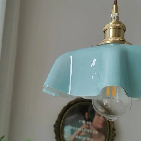 Close view of the blue scalloped rim with a clear bulb hanging below it