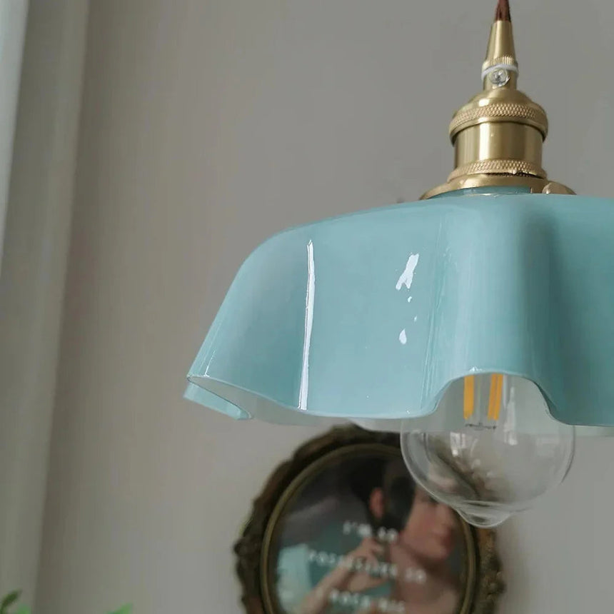 Close view of the blue scalloped rim with a clear bulb hanging below it