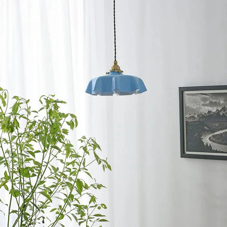 Blue scalloped shade between a trailing plant and a framed black print