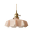 Pink scalloped glass shade with a brass top on a plain white background