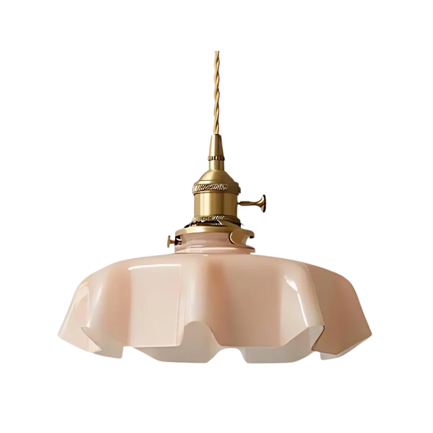 Pink scalloped glass shade with a brass top on a plain white background