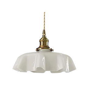 White scalloped glass shade with a brass top on a plain white background