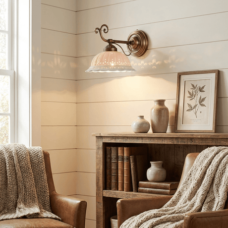 The sconce on a shiplap wall above a wood bookcase between two armchairs