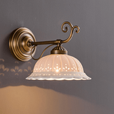 The horizontal arm style with curled details above the ceramic shade, lit