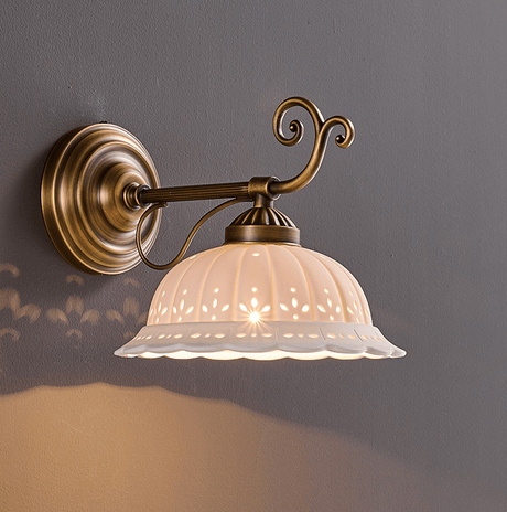 The horizontal arm style with curled details above the ceramic shade, lit