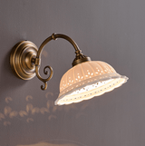 The scroll arm style lit, points of light passing through the pierced leaf pattern