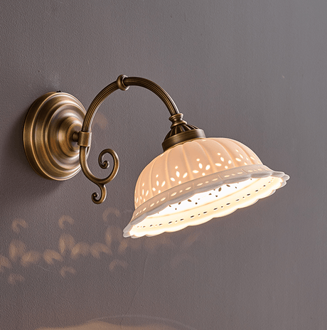 The scroll arm style lit, points of light passing through the pierced leaf pattern