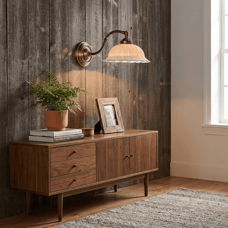 The sconce on a weathered wood wall above a walnut sideboard with a plant