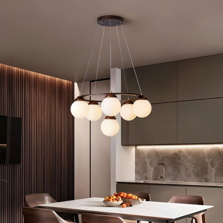 The ring lit over a kitchen dining table with chairs and a fluted wood wall