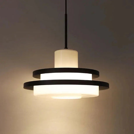 Black disc pendant lit in a dark room