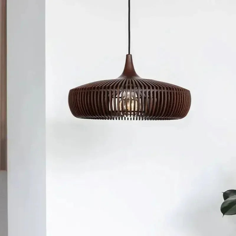Walnut slatted shade against a white wall beside a plant