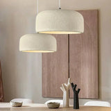 Textured dome pendant lit in an interior with wood and plaster surfaces