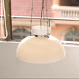 The cream dome lit above a table beside a window with a balcony behind