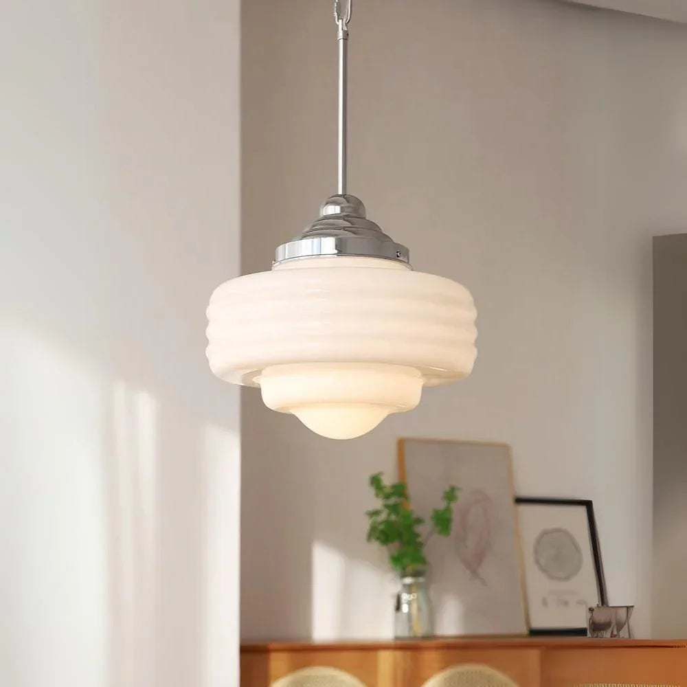 Stepped white opal shade with a chrome top above a sunlit desk corner