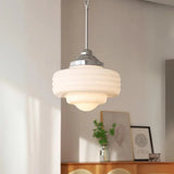 Stepped white opal shade with a chrome top above a sunlit desk corner