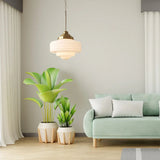 Opal shade lit in a living room with a green sofa and three potted plants
