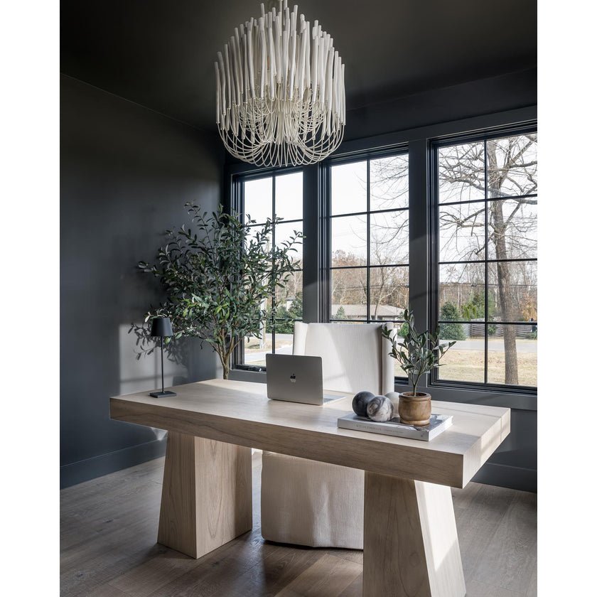 The fitting lit above a wood console table against a dark wall