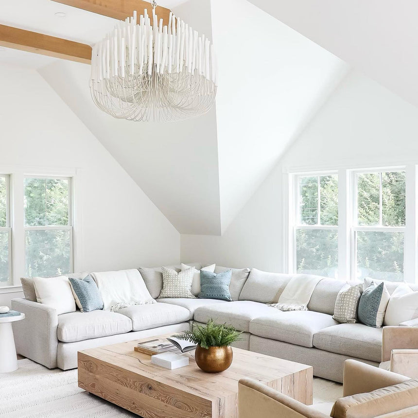 The rods lit above a deep sectional sofa in a pale living room