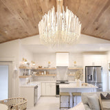 The fitting lit above a white kitchen with a timber plank ceiling