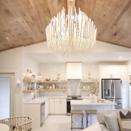 The fitting lit above a white kitchen with a timber plank ceiling