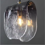 Close view of the folded glass with the filament bulb glowing inside it