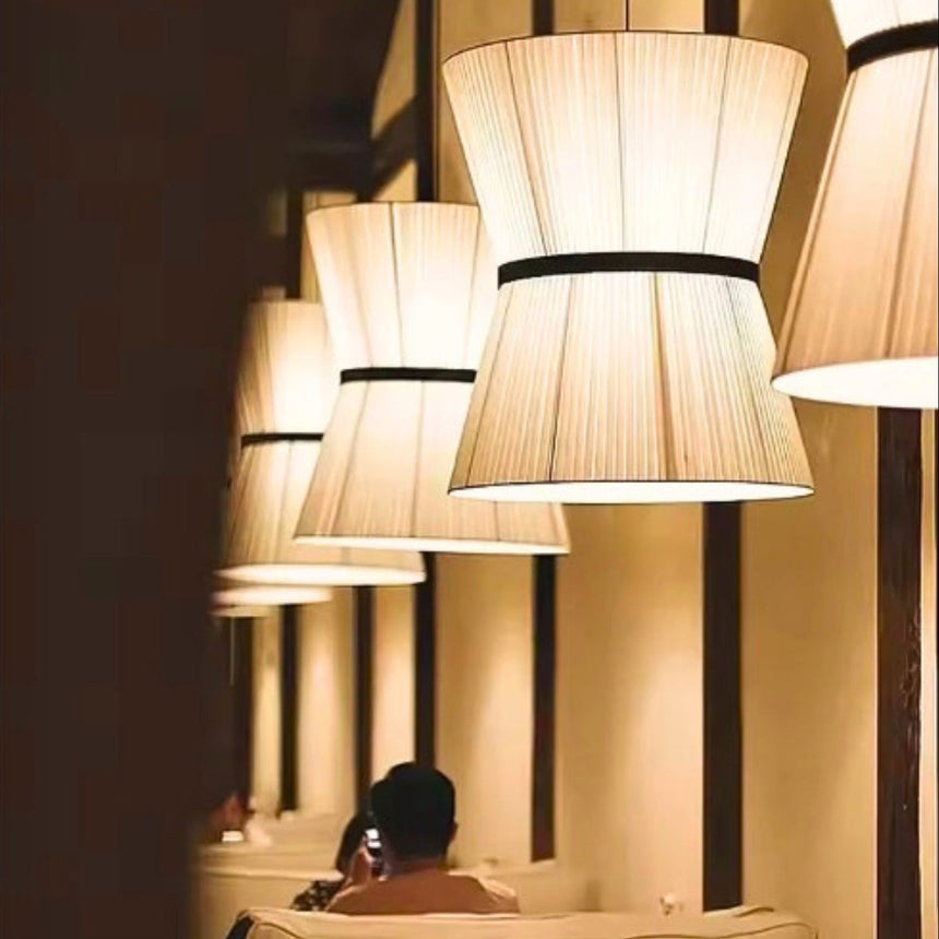 Knitted hourglass shade hung in a pale room