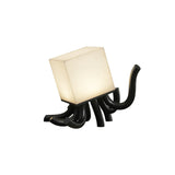 Sculptural table lamp with black carved roots seen from the front