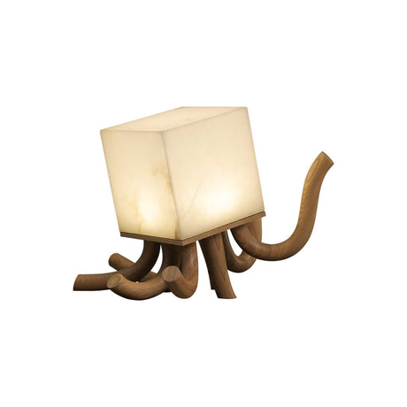 Sculptural table lamp in light wood seen at an angle and lit