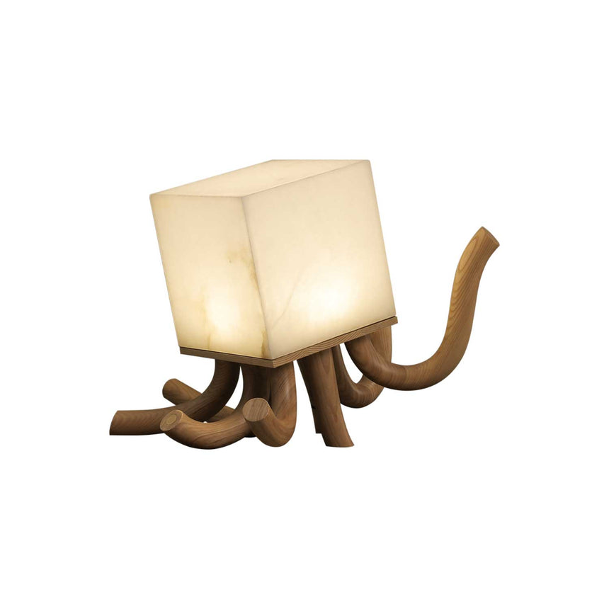 Sculptural table lamp in light wood seen at an angle and lit