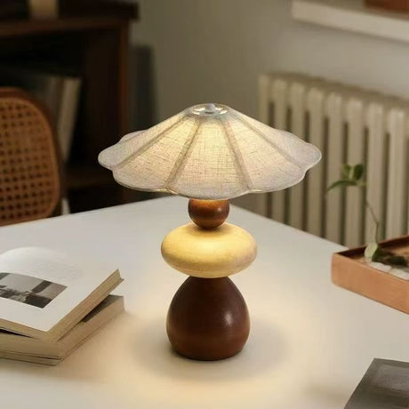 Sculptural table lamp on a white desk beside open magazines
