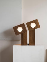 Two teak lamps seen from an angle with the cord running down