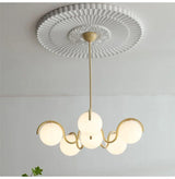 Brass stem and cream arms seen from below against a white ceiling