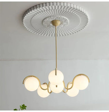 Brass stem and cream arms seen from below against a white ceiling