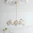 Cream curved arms with opal globes under a molded white ceiling rose