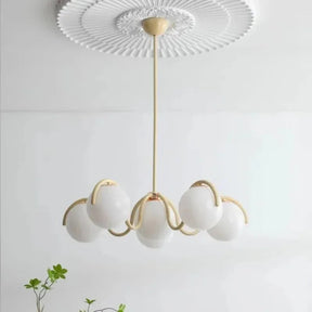 Cream curved arms with opal globes under a molded white ceiling rose