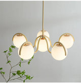 Cream arms and globes lit beside a trailing green plant