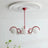 Red curved arms with opal globes under a molded white ceiling rose